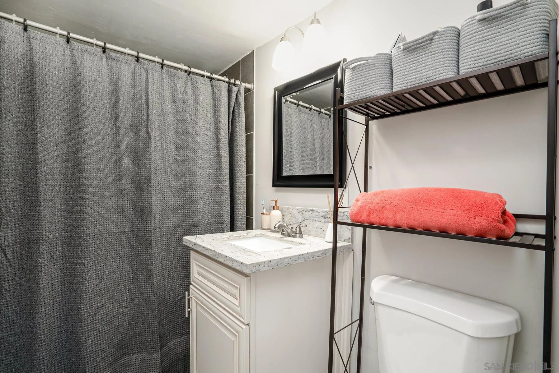 8531 Gardena Road Lakeside, CA 92040 - Photo 15 of 29 a bathroom with a sink a toilet a mirror and shower curtain