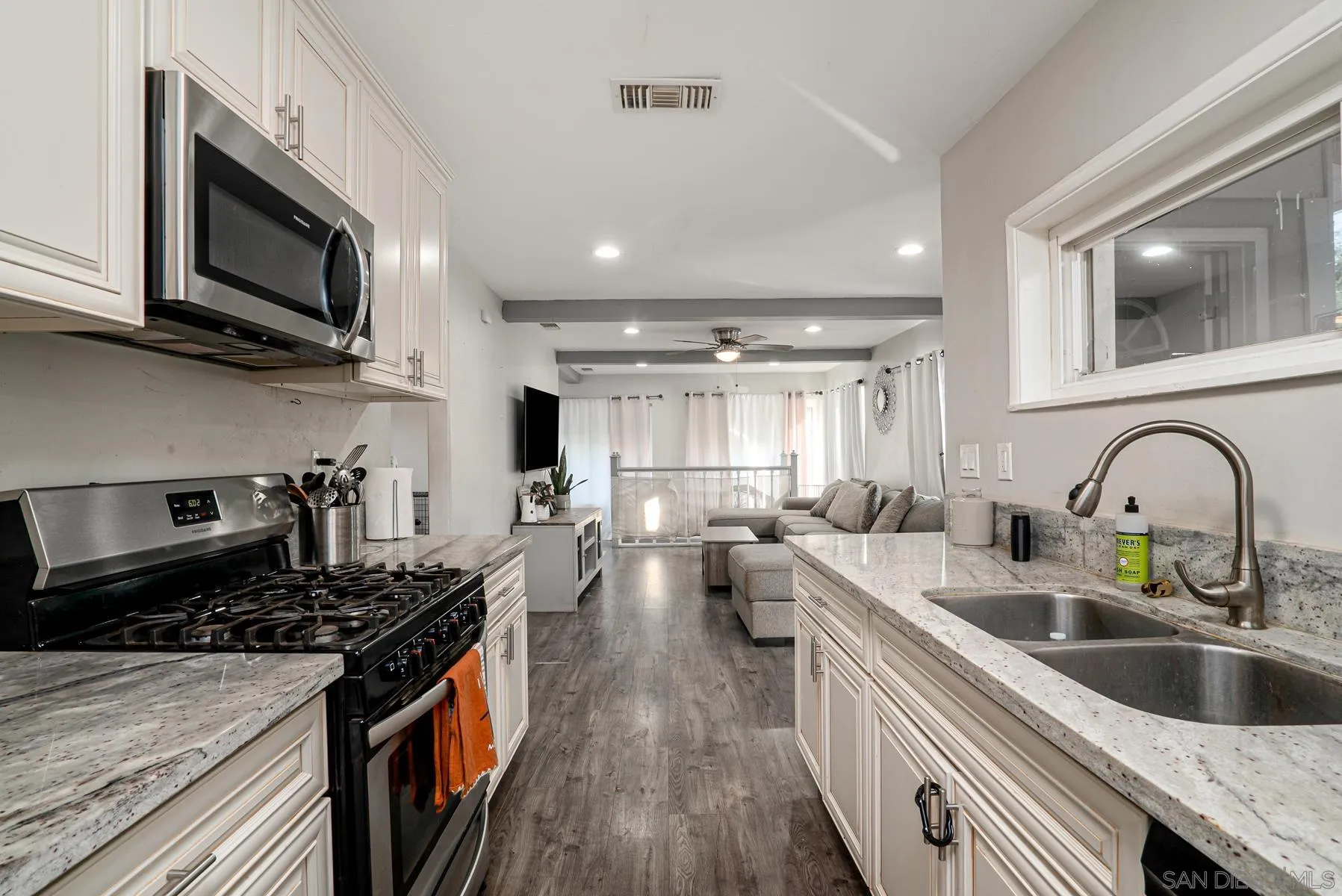 8531 Gardena Road Lakeside, CA 92040 - Photo 9 of 29 a kitchen with lots of counter top space a sink wooden floor and stainless steel appliances