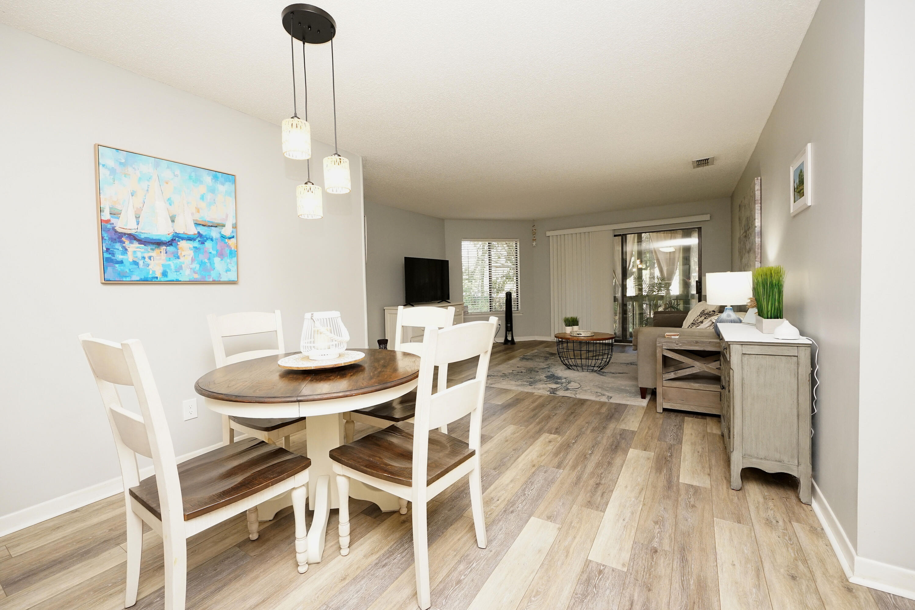 55 Bay Drive, Unit 2202 Niceville, FL 32578 - Photo 11 of 29 a view of a dining room with furniture a chandelier and wooden floor
