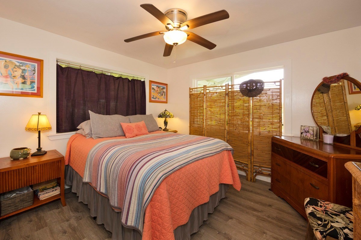 15-1565 Beach Road Keaau, HI 96749 - Photo 18 of 27 a bedroom with a bed a dresser and a chandelier