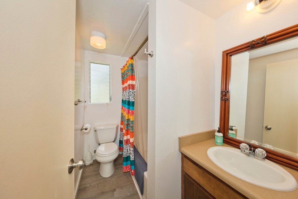15-1565 Beach Road Keaau, HI 96749 - Photo 26 of 27 a bathroom with a sink vanity mirror and toilet