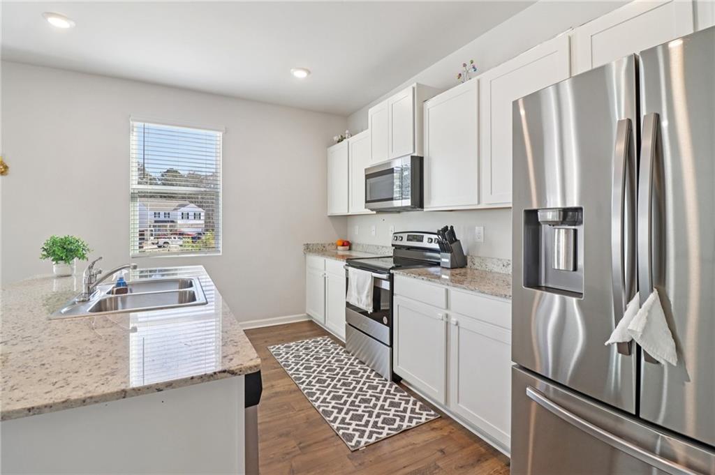 113 Deer Run Drive Dallas, GA 30132 - Photo 9 of 25 a kitchen with white cabinets and stainless steel appliances