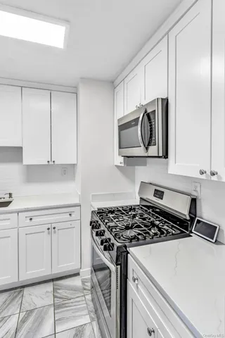 a kitchen with white cabinets and appliances