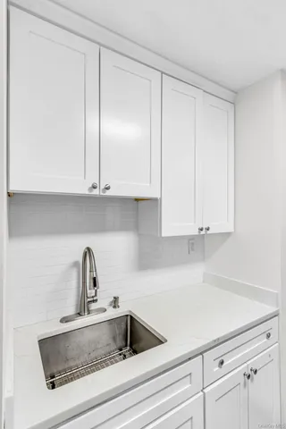 a kitchen with white cabinets and a sink
