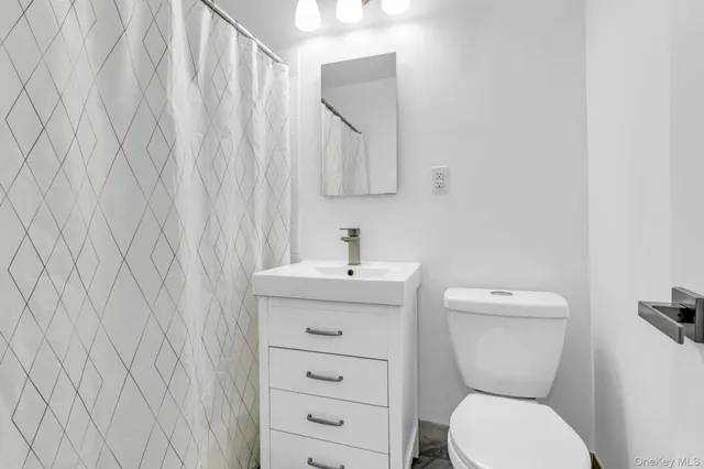 a bathroom with a toilet a sink and mirror