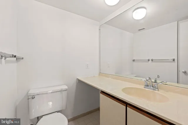 a bathroom with a sink toilet vanity and a mirror