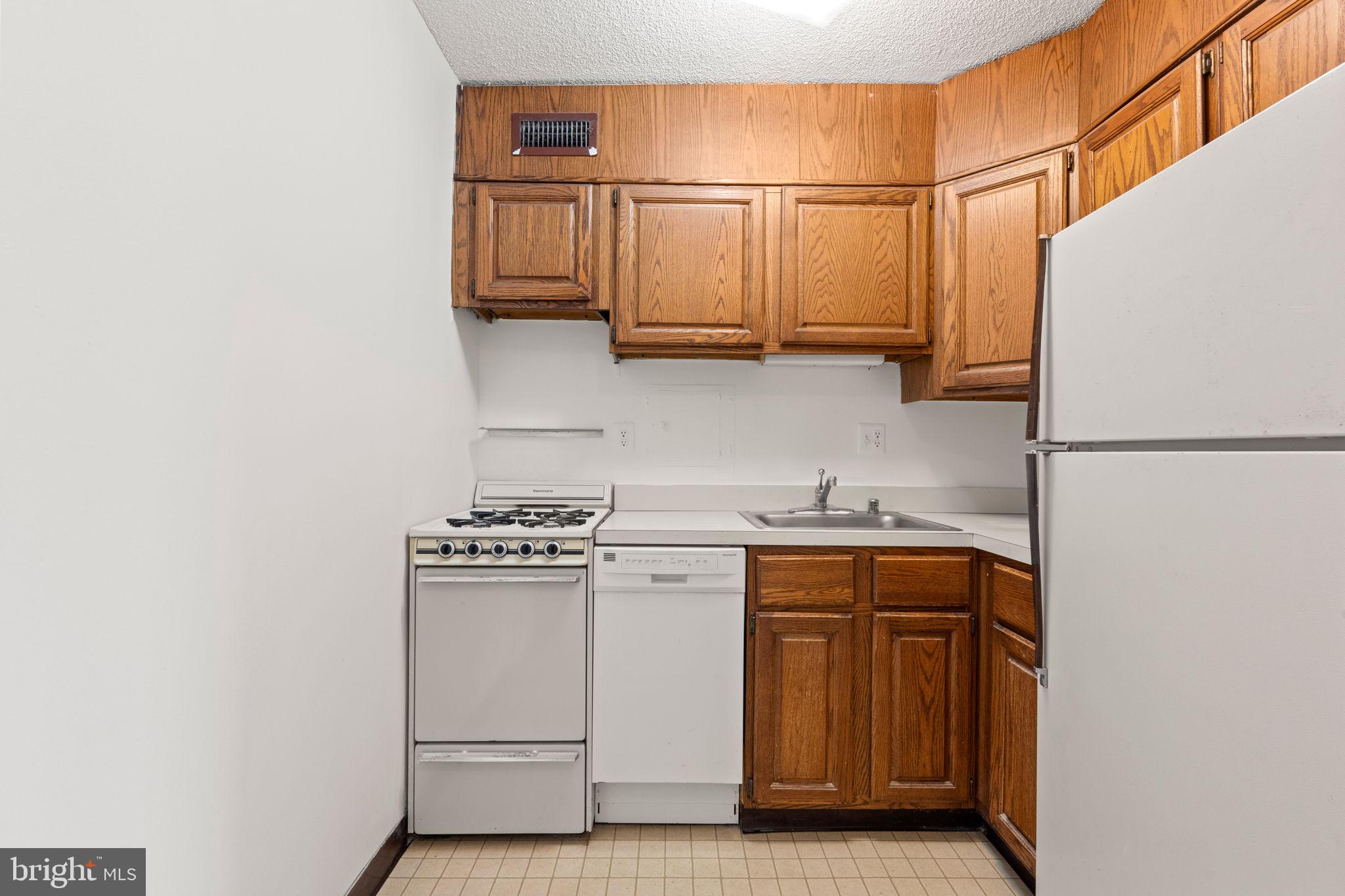 300 M Street Southwest, Unit N213 Washington, DC 20024 - Photo 8 of 14 a kitchen with stainless steel appliances granite countertop a sink and a stove