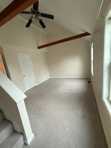 a view of a room with a ceiling fan and window