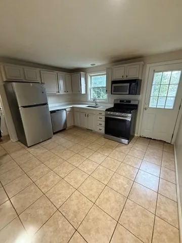 a kitchen with stainless steel appliances a refrigerator sink and cabinets