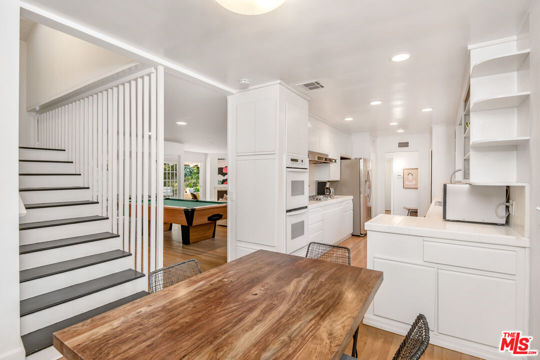 16849 Adlon Road Encino, CA 91436 - Photo 12 of 40 a open kitchen with white cabinets and stainless steel appliances