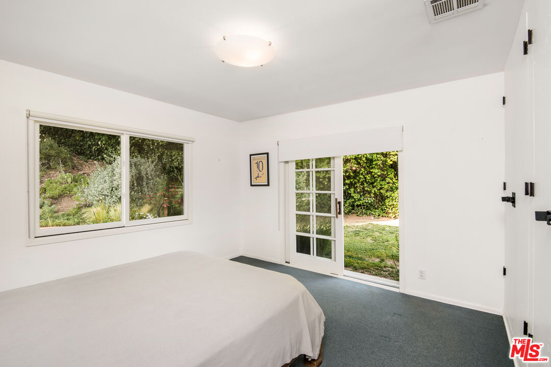 16849 Adlon Road Encino, CA 91436 - Photo 21 of 40 a bed sitting in a bedroom next to a window