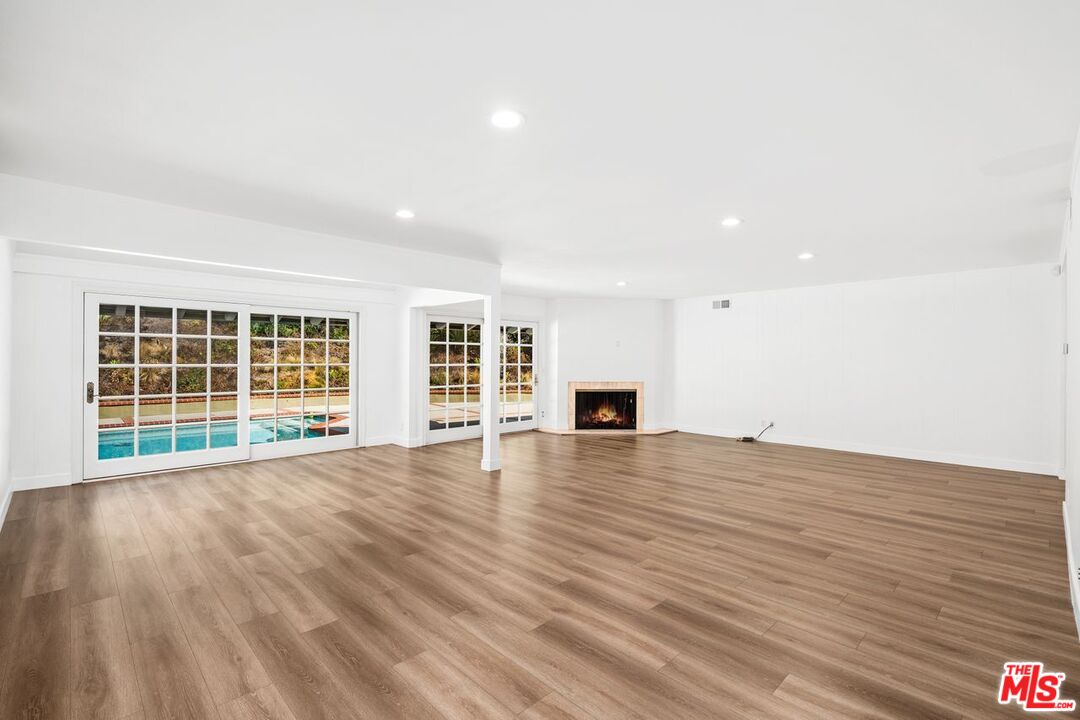 16849 Adlon Road Encino, CA 91436 - Photo 36 of 40 a view of empty room with wooden floor and fireplace
