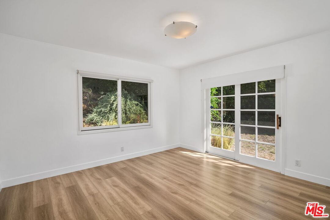 16849 Adlon Road Encino, CA 91436 - Photo 39 of 40 an empty room with wooden floor and windows
