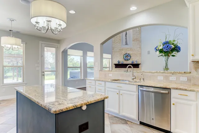 a bathroom with a granite countertop sink a large mirror and a window