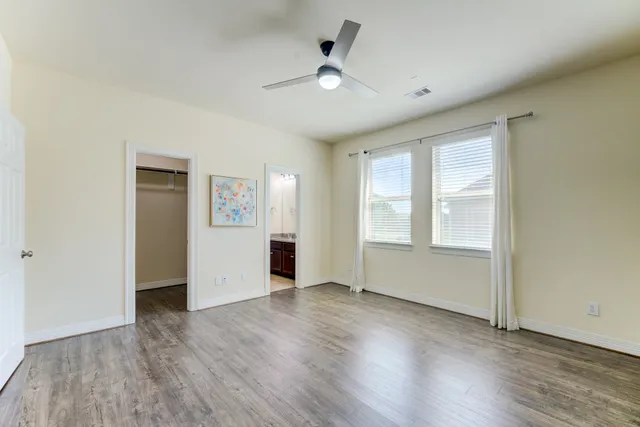an empty room with wooden floor and windows