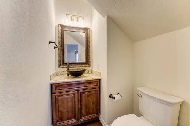 a bathroom with a toilet a sink and mirror