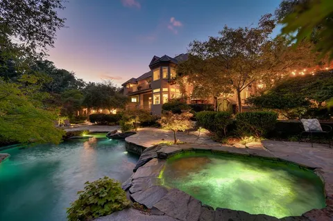 an aerial view of a house with swimming pool and lake view