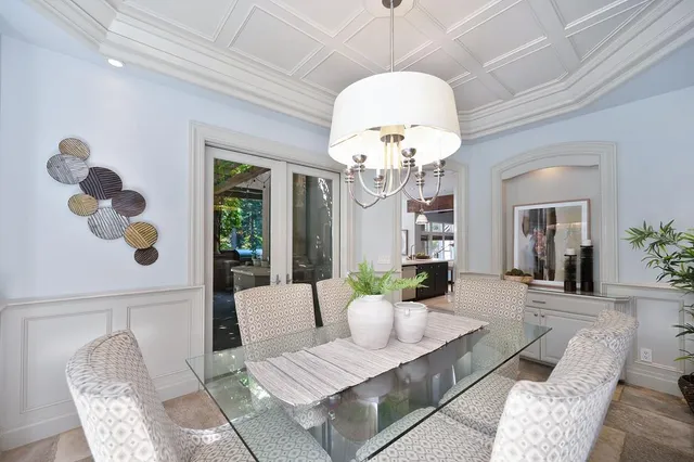 a dining room with furniture a chandelier and window
