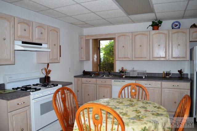 365 Buckeye Ridge Run Sparta, NC 28675 - Photo 4 of 37 a kitchen with stainless steel appliances granite countertop a kitchen island a stove a sink a dining table and chairs