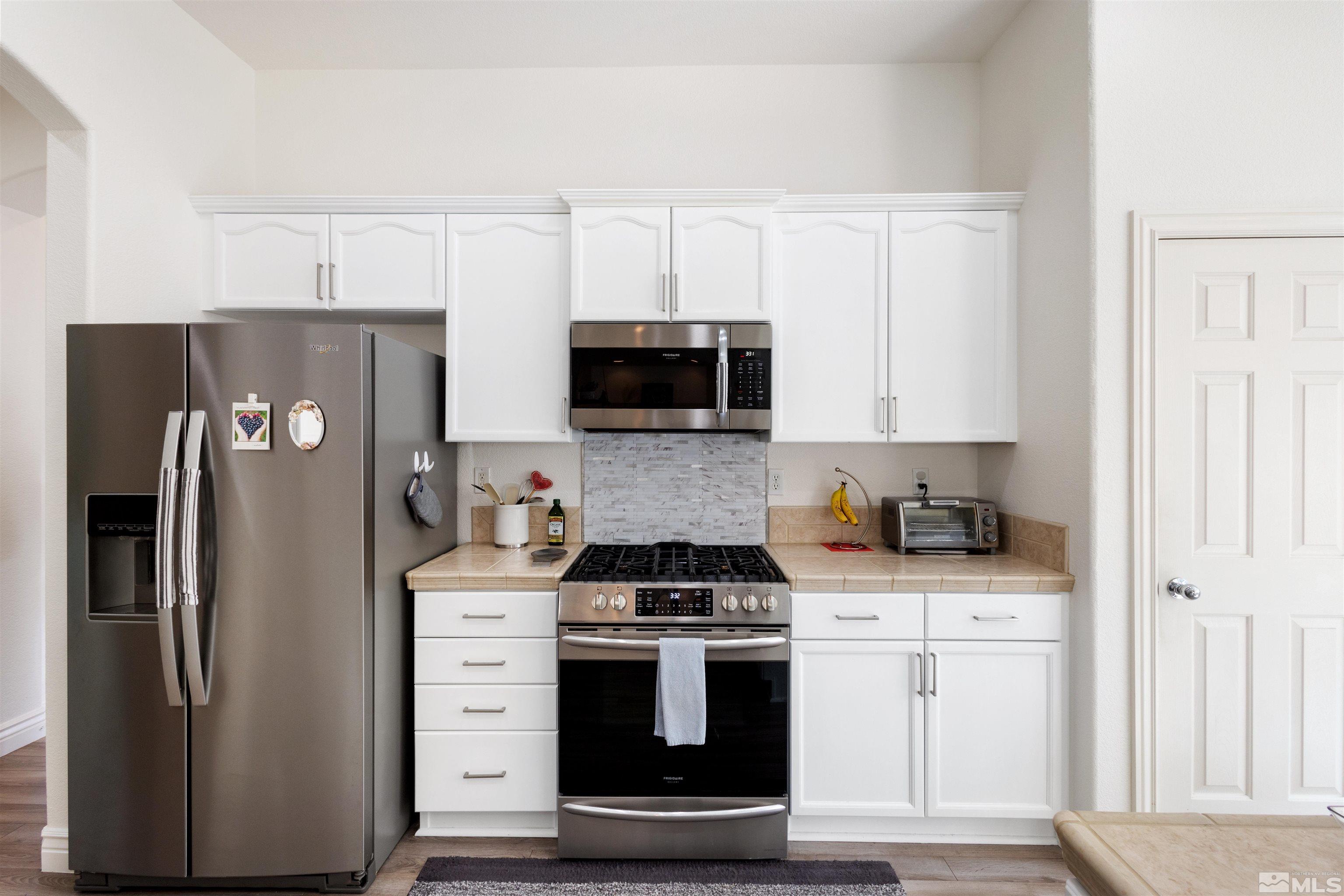 10521 Fort Morgan Way Reno, NV 89521 - Photo 16 of 35 a kitchen with stainless steel appliances a stove a refrigerator a sink and cabinets