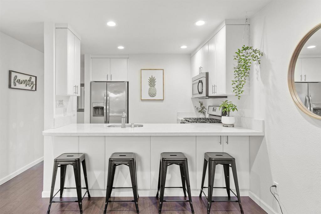 a white kitchen with cabinets and chairs