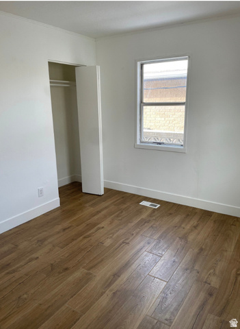 230 North 2nd Street Tooele, UT 84074 - Photo 14 of 18 Light-filled room featuring wood-finish flooring, white walls, a double-hung window, and an open closet with hanging rod