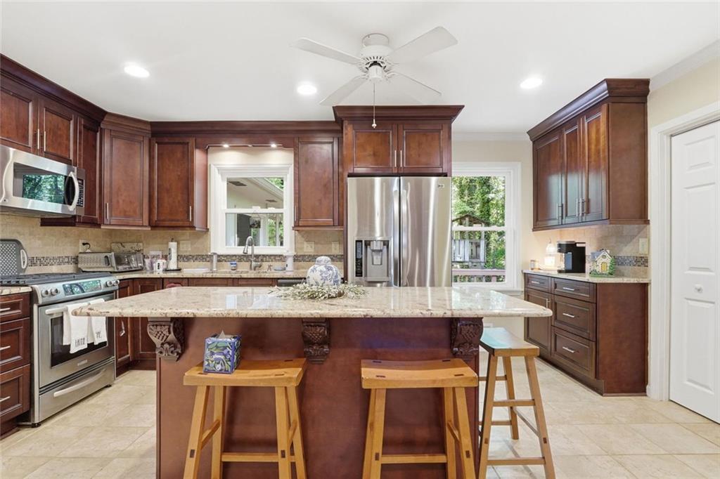 1837 Chancery Lane Atlanta, GA 30341 - Photo 11 of 46 a kitchen with stainless steel appliances granite countertop a stove top oven a refrigerator a sink and a dining table with white cabinets