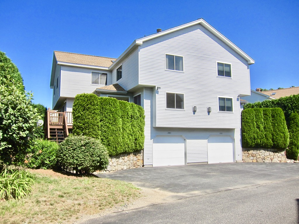243 Captain Eames Circle, Unit 243 Ashland, MA 01721 - Photo 1 of 16 a view of a white house with large windows and a small yard