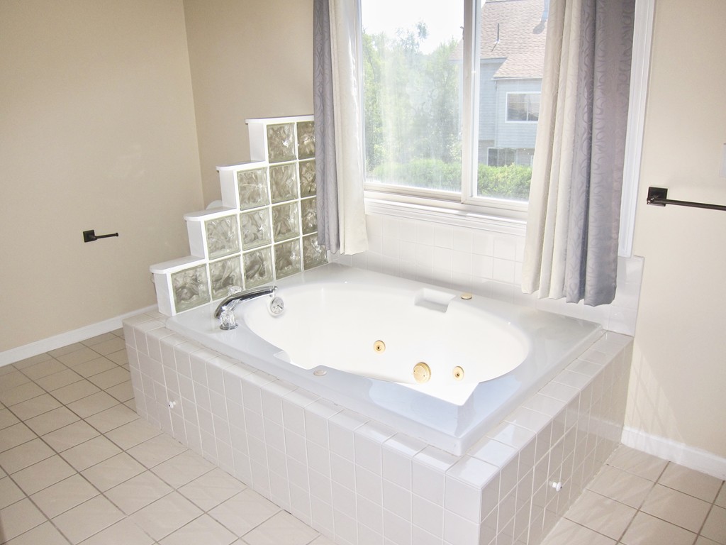 243 Captain Eames Circle, Unit 243 Ashland, MA 01721 - Photo 11 of 16 a bath tub sitting next to a window