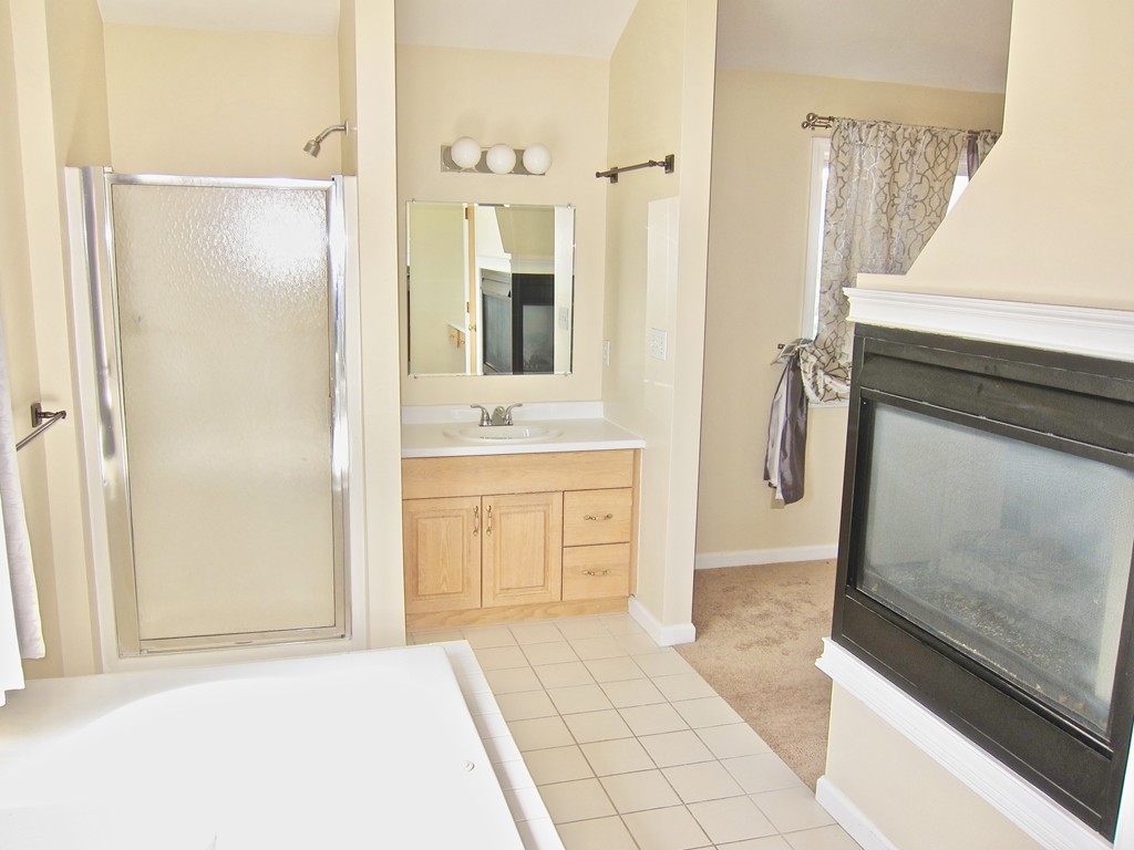 243 Captain Eames Circle, Unit 243 Ashland, MA 01721 - Photo 12 of 16 a bathroom with a shower sink and mirror