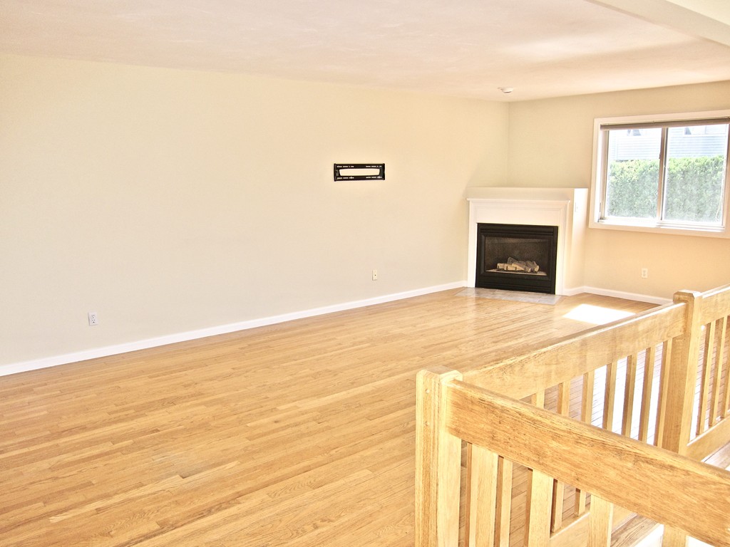 243 Captain Eames Circle, Unit 243 Ashland, MA 01721 - Photo 5 of 16 a view of an empty room with wooden floor and a window