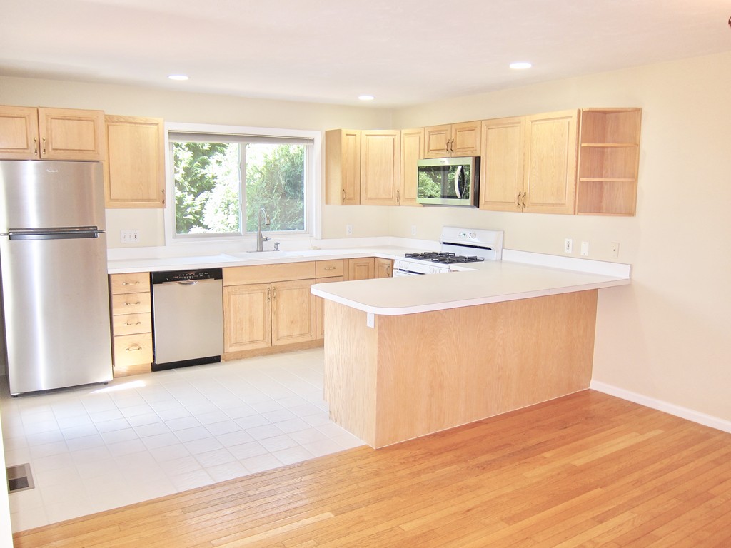 243 Captain Eames Circle, Unit 243 Ashland, MA 01721 - Photo 6 of 16 a kitchen with stainless steel appliances granite countertop a stove a sink and a refrigerator