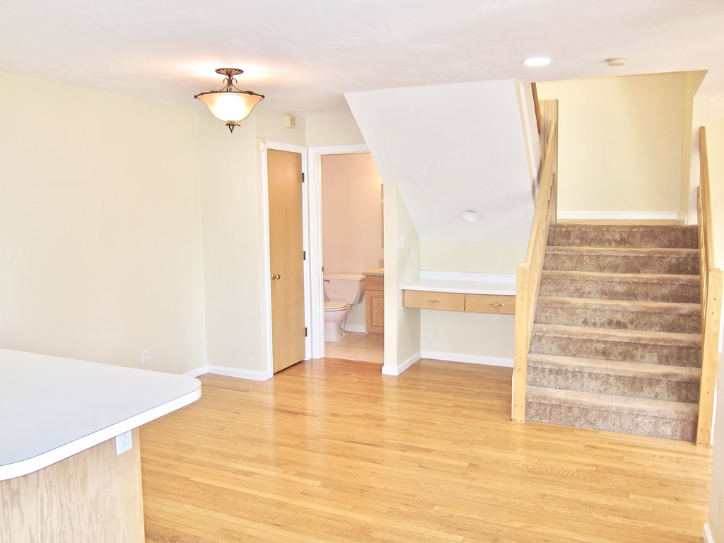 243 Captain Eames Circle, Unit 243 Ashland, MA 01721 - Photo 8 of 16 a view of an empty room with wooden floor and a bathroom