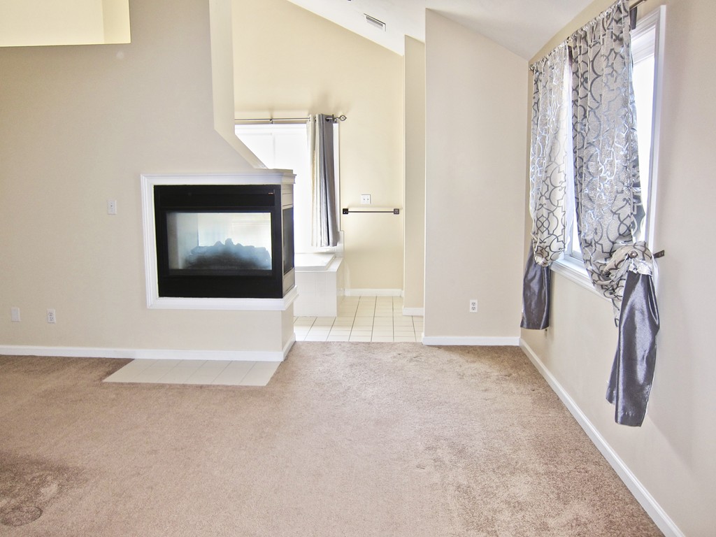 243 Captain Eames Circle, Unit 243 Ashland, MA 01721 - Photo 9 of 16 a view of an empty room with a fireplace