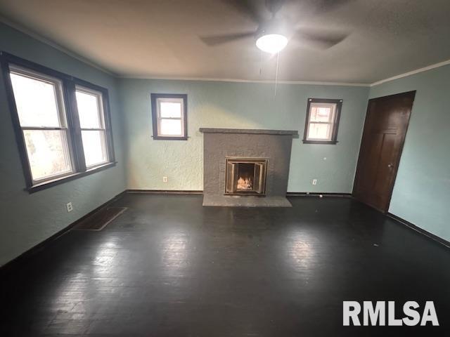 1013 North 2nd Street Clinton, IA 52732 - Photo 2 of 14 an empty room with windows fireplace and wooden floor