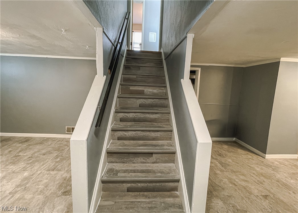 24709 Emery Road Warrensville Heights, OH 44128 - Photo 27 of 34 Stairs featuring crown molding