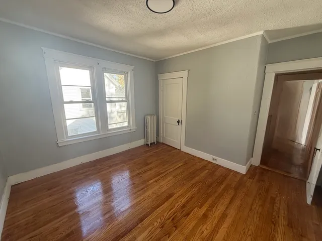 an empty room with wooden floor and window
