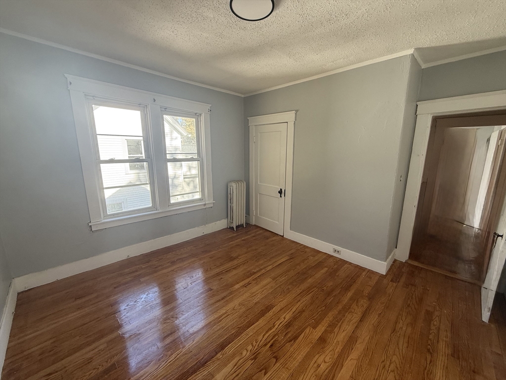 an empty room with wooden floor and window