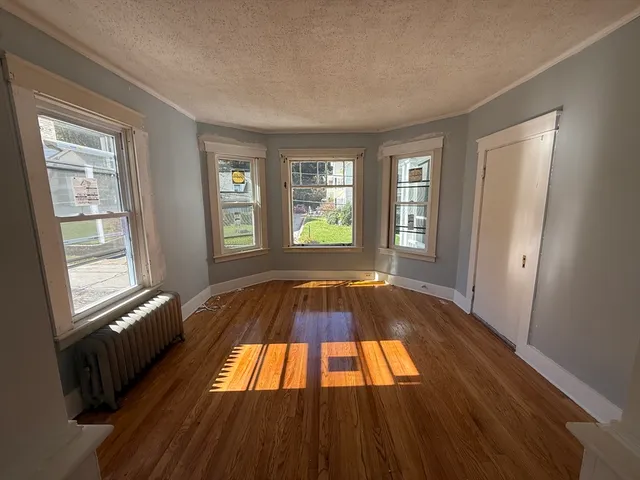 a view of a livingroom with wooden floor and window