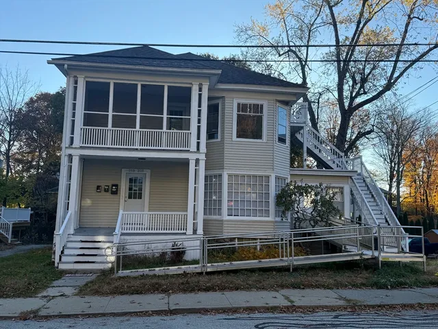 a view of a house with a yard and large tree