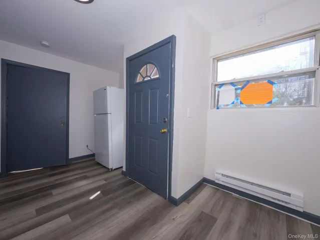 an empty room with wooden floor and window