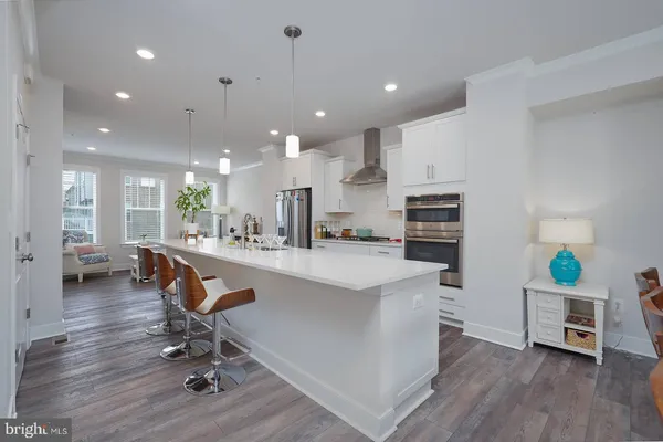 a large kitchen with stainless steel appliances lots of counter space and a sink