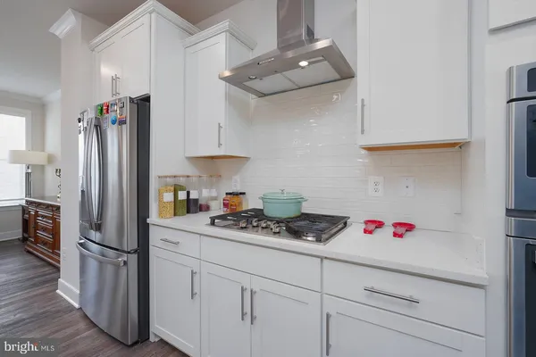 a large white kitchen with lots of counter space and stainless steel appliances