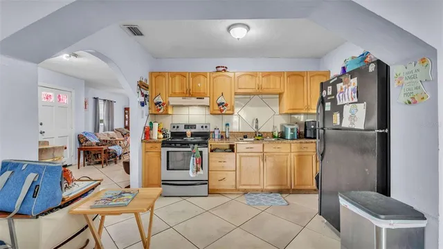 a kitchen with stainless steel appliances granite countertop a refrigerator and a stove top oven
