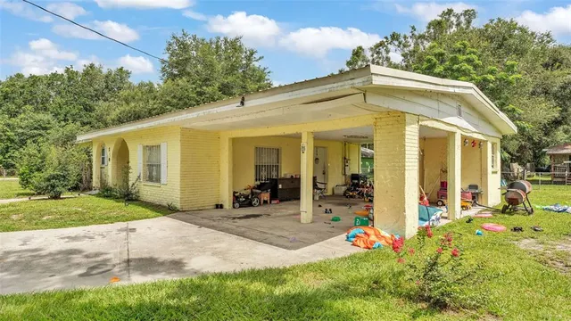 a view of a house with a backyard and a tree