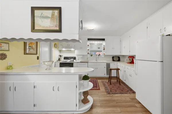 a living room with stainless steel appliances kitchen island granite countertop furniture and a refrigerator