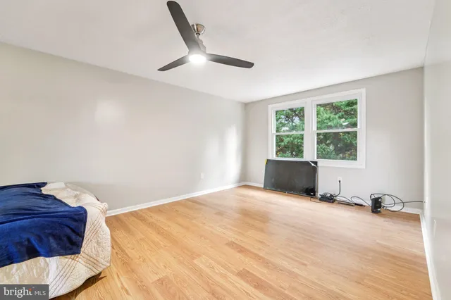 a view of an empty room with wooden floor and stairs