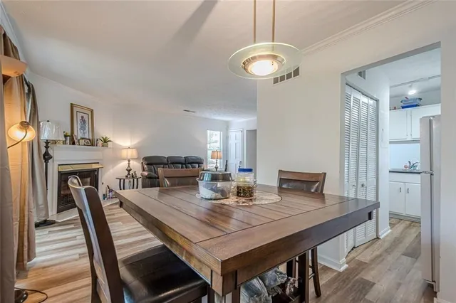 a view of a dining room with furniture a rug and wooden floor