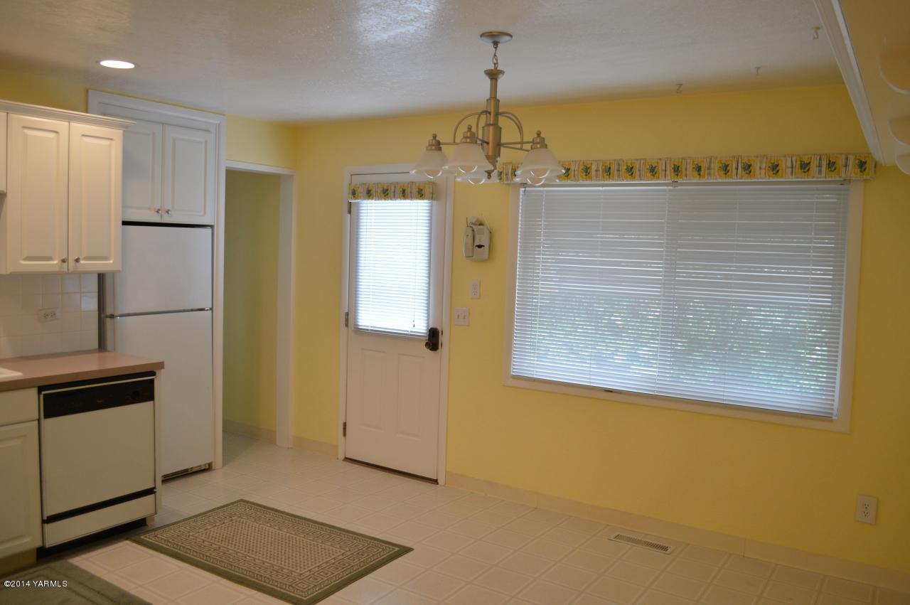 7007 Bell Road Yakima, WA 98901 - Photo 8 of 15 a view of a kitchen with a refrigerator cabinets and a wooden floor