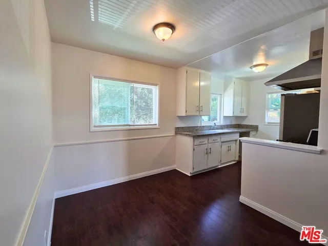 a kitchen with counter top space and wooden floor